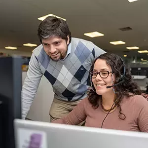 Nestlé employees collaborating at a computer in a modern office workspace